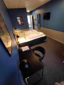 Zimmer mit 2 Betten, einem Schreibtisch und einem Tisch in der Unterkunft Km City Room 3 On Pedestrian Street Sby in Sæby