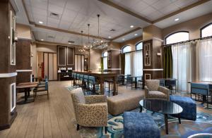 a lobby with chairs and tables and a dining room at Hampton Inn Belmont at Montcross in Belmont