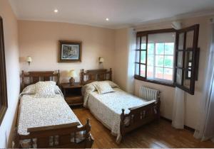 een slaapkamer met 2 bedden en een raam bij Casa Eudosia in Barro