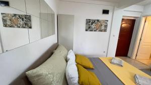 a bedroom with a bed with yellow pillows at Voždovac Vitanovacka in Belgrade