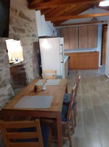 uma cozinha com uma mesa de madeira com cadeiras e um frigorífico em Traditional Aesthetic 1 Bedroom Apartment em Kalamata