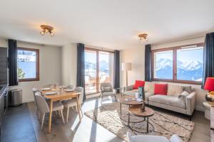 ein Wohnzimmer mit einem Sofa und einem Tisch in der Unterkunft Résidence Les Fermes De L'alpe - 3 Pièces pour 6 Personnes 584 in Huez