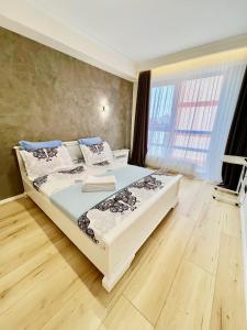 ein Schlafzimmer mit einem Bett und einem großen Fenster in der Unterkunft Apartament Chisinau in Chişinău