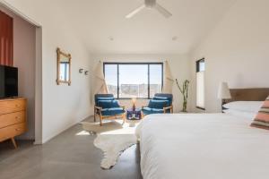 um quarto com duas cadeiras azuis e uma cama em Yucca Hut - Design Forward Oasis Near Joshua Tree em Joshua Tree