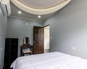 a bedroom with a white bed and a ceiling at Villa el Descanso in San Pedro