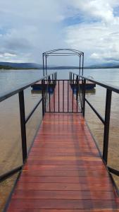サン・ジョゼー・ダ・バーハにあるCasa de temporada no Lago de Furnas-acesso a represaの水上に椅子2脚が置かれた桟橋