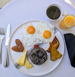 a plate with eggs and toast and a cup of coffee at Colours LGBTIQ Boutique Hotel & Hostal Coliving in San José