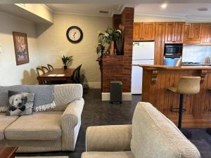 a living room with a couch and a kitchen at Porters Cottage Garden in Albury