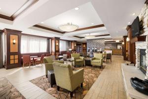 - un hall d'un hôtel avec des chaises et une cheminée dans l'établissement Hampton Inn McHenry, à McHenry