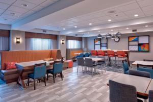 a restaurant with tables and chairs in a room at Hampton Inn Norfolk in Norfolk