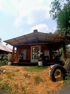 una casa con un neumático grande delante de ella en Hostal La Cabaña, en Mesetas