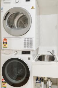 een wasmachine en een wastafel in de keuken bij StayCentral - Merigold 21 on Collins (CBD) in Melbourne