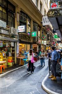 een groep mensen die door een drukke straat lopen bij StayCentral - Merigold 21 on Collins (CBD) in Melbourne