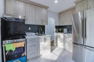 a kitchen with wooden cabinets and a stainless steel refrigerator at Beautiful 3 bedroom house, 20 minutes to Toronto downtown, free parking and Wifi in Toronto