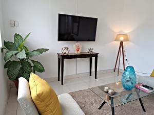 ein Wohnzimmer mit einem TV und einem Tisch in der Unterkunft Exclusivo departamento Céntrico con Terraza in Ferreñafe