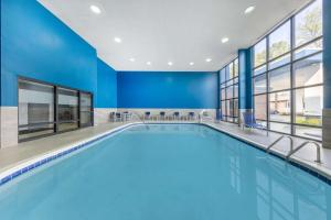 a swimming pool in a building with blue walls and windows at Hampton Inn Richmond/Midlothian Turnpike in Midlothian