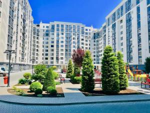 ein Park mit Bäumen und Bänken vor einem großen Gebäude in der Unterkunft Apartament Chisinau in Chişinău