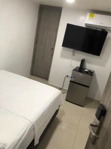 een slaapkamer met een bed en een flatscreen-tv bij Apartamentos Rodadero Nabusimake11 in Rodadero