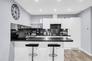 a kitchen with a counter and a clock on the wall at Hellena Lodge in Aberdeen