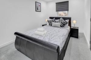 a bedroom with a large bed with a black leather headboard at Hellena Lodge in Aberdeen