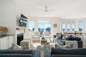 sala de estar con sofás azules y TV en Coastal Vista - Walk to Emerald Isle Beach!, en Emerald Isle