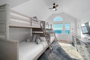 een slaapkamer met twee stapelbedden en een bureau bij Coastal Vista - Walk to Emerald Isle Beach! in Emerald Isle +37 foto's