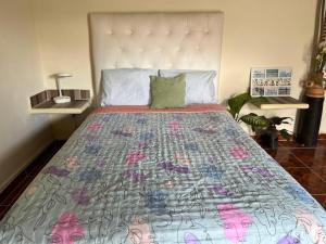 a bedroom with a large bed with a quilt on it at Rústico Mayan in Cancún