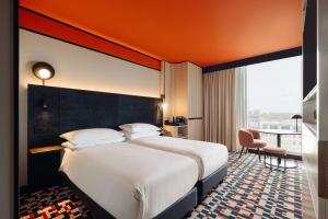 アムステルダムにあるダブルツリー　バイ　ヒルトン　アムステルダム　セントラル　ステーションの大きなベッドと大きな窓が備わるホテルルームです。