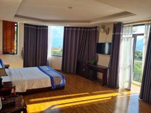 a hotel room with a bed and a large window at Minh Sơn Hotel in Ta Lan Than