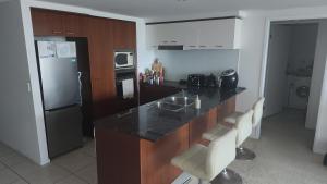 a kitchen with a counter and a refrigerator at Darren Surfers Apartment in Gold Coast