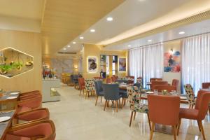 a dining room with tables and chairs in a restaurant at Hampton by Hilton Vadodara-Alkapuri in Vadodara