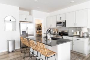 a kitchen with white cabinets and a black counter top at Playground, Family Home, Waffle Bar, 3 Tvs in Meridian