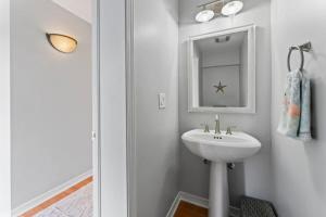 Un baño blanco con lavabo y espejo. en Gone Coastal - Oceanfront Home with a Hotub, en Ponte Vedra Beach