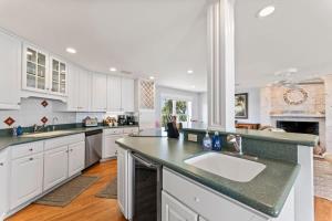 una cocina con armarios blancos y un lavabo grande en Gone Coastal - Oceanfront Home with a Hotub, en Ponte Vedra Beach 49 fotos más