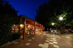 a restaurant with tables and chairs at night at Yildiz Pension Bungalows in Cıralı