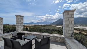 uma varanda com cadeiras e vista para as montanhas em Sabaton Apartment em Leonidio