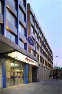 un hotel con una bandera en la parte delantera en Hampton by Hilton Newcastle en Newcastle