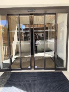 un accès à un bâtiment avec des portes en verre dans l'établissement Résidence Hauts De La Vanoise - Studio pour 2 Personnes 24, à Val Thorens