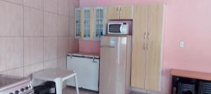 Il comprend une petite cuisine équipée d'un four micro-ondes et d'un réfrigérateur. dans l'établissement Casa com piscina, à Mairiporã