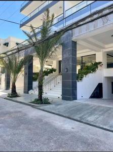 un bâtiment avec des palmiers en face de celui-ci dans l'établissement Apartamento en bella vista, à Saint-Domingue