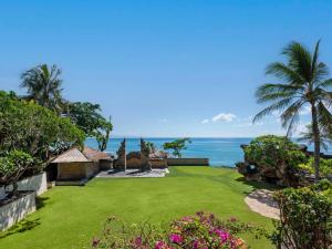 een tuin met de oceaan op de achtergrond bij Hilton Bali Resort in Nusa Dua