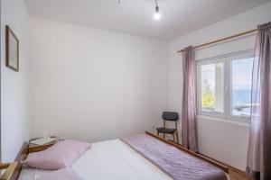 um quarto com uma cama, uma janela e uma cadeira em Seaside secluded apartments Cove Vela Borova, Korcula - 15062 em Prizba