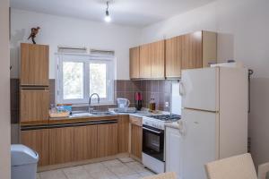 uma cozinha com armários de madeira e um frigorífico branco em Seaside secluded apartments Cove Vela Borova, Korcula - 15062 em Prizba