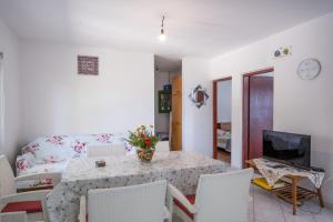 uma sala de estar com uma mesa e um sofá em Seaside secluded apartments Cove Vela Borova, Korcula - 15062 em Prizba