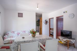 a living room with a table and a couch at Seaside secluded apartments Cove Vela Borova, Korcula - 15062 in Prizba