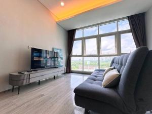 a living room with a couch and a flat screen tv at Pinetree Marina Resort by WP HOMESTAY in Johor Bahru