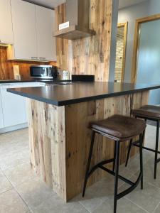 a kitchen with a wooden counter with two stools at North Coast Place in Marquette