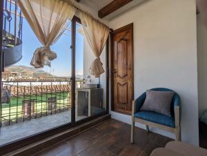 een kamer met een stoel en een groot raam bij Vista Volcan in Antigua Guatemala