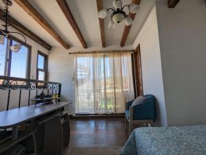 Schlafzimmer mit einem Bett, einem Schreibtisch und einem Fenster in der Unterkunft Vista Volcan in Antigua Guatemala