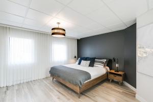 een slaapkamer met een bed en een blauwe muur bij Complexe La Voûte by KASANIA - Condo 201 in Laval